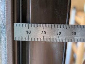 チリ (扉のすき間) を定規で測っている様子